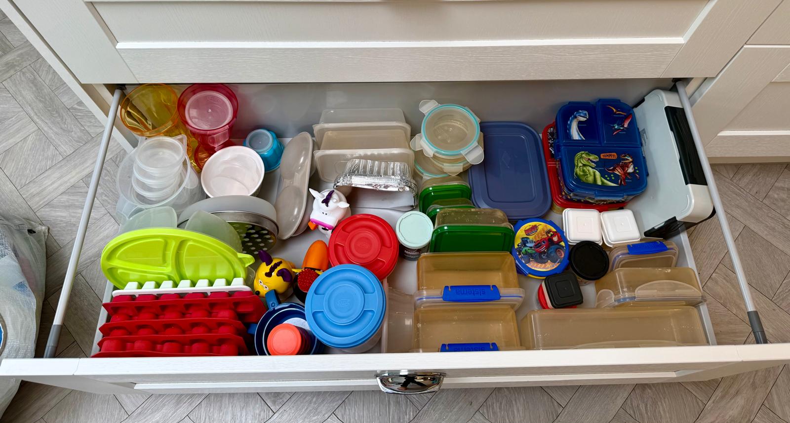 Family kitchen drawer organised into clear zones for lunchboxes, tubs and food containers