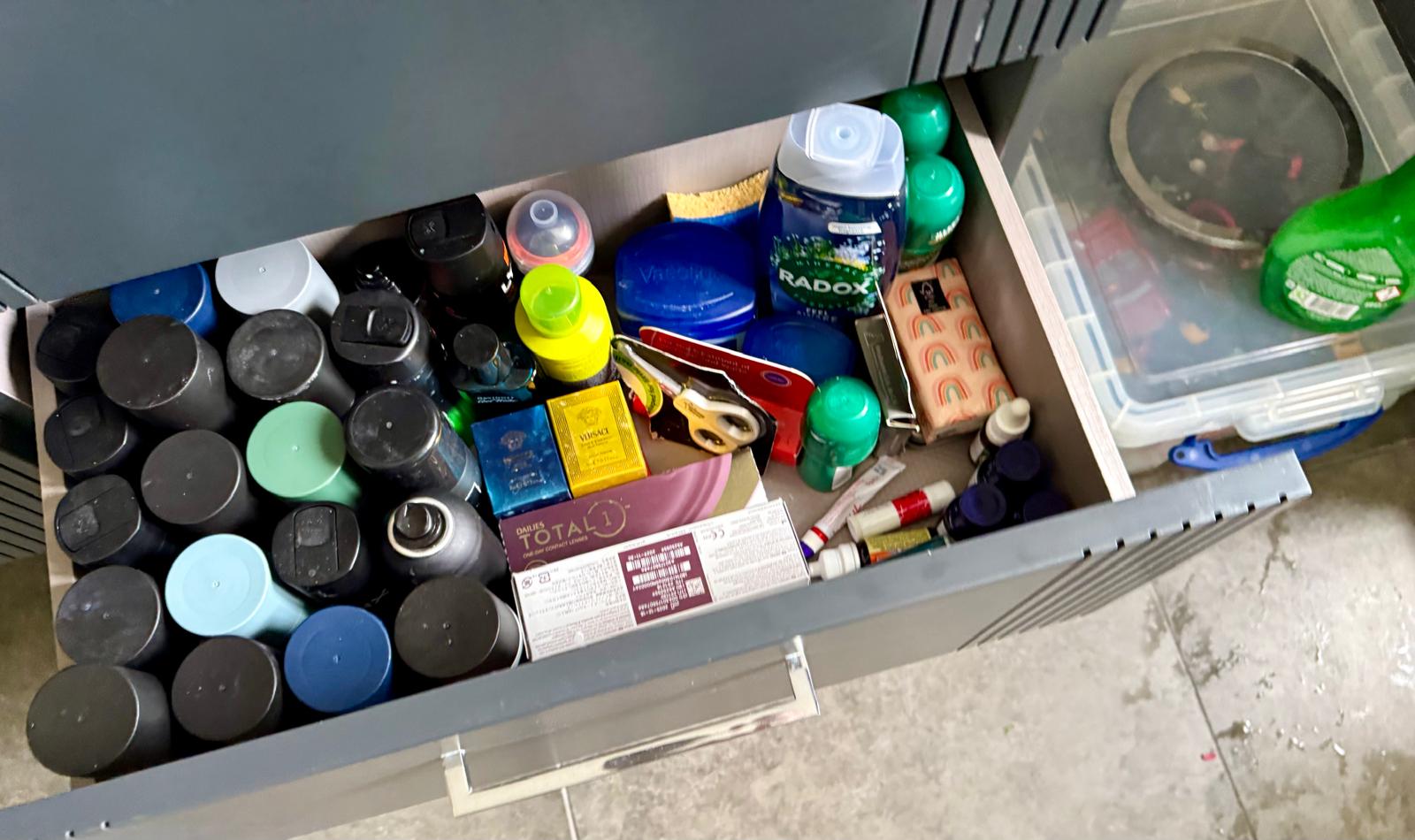 Cluttered bathroom drawer before a professional home organisation session in Essex