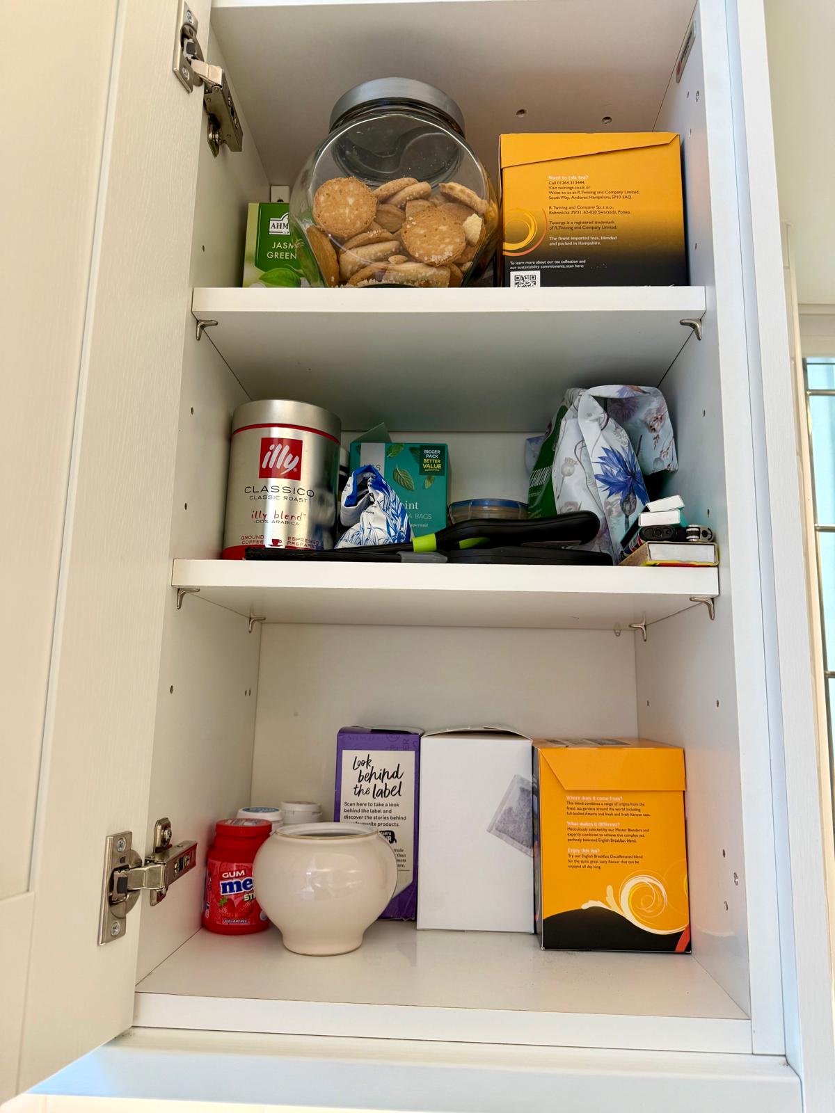 Kitchen tea and coffee cupboard organised across three shelves with jars and boxed teas